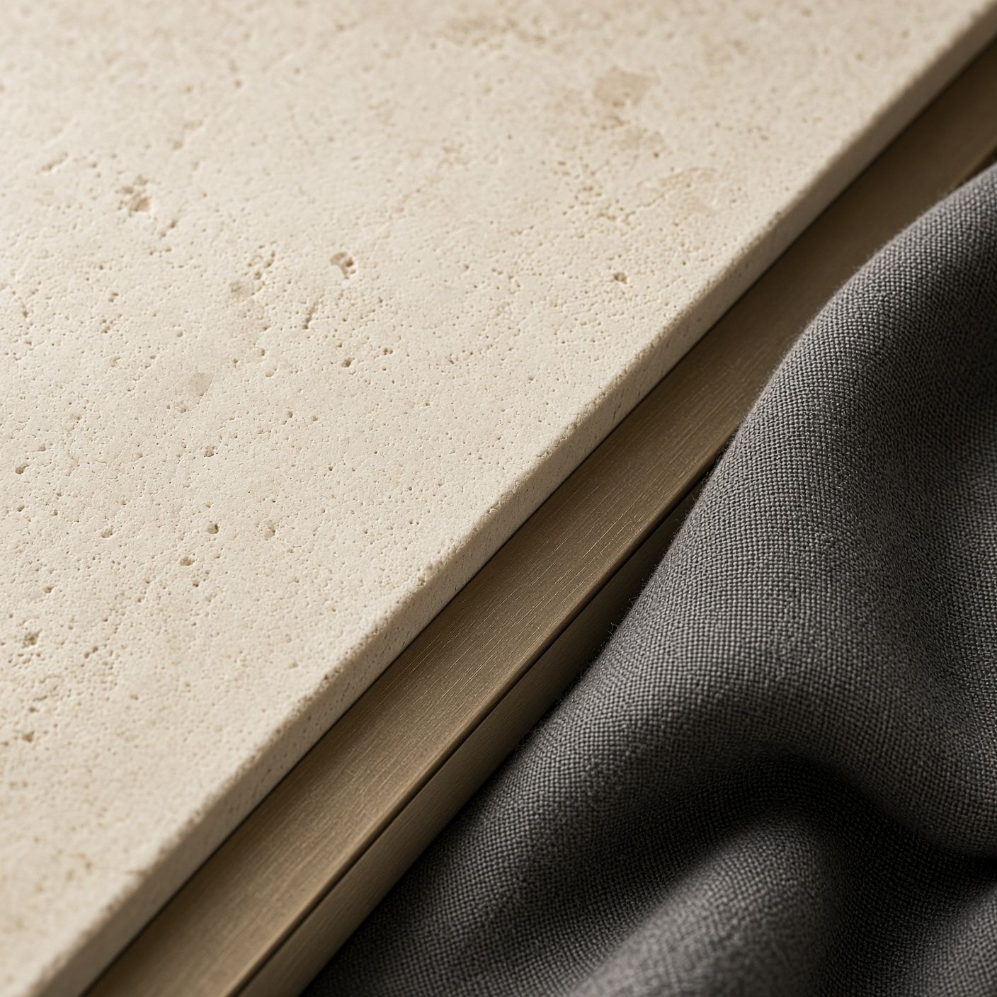 Limestone, a bronze inlay, and charcoal linen in raking light.
